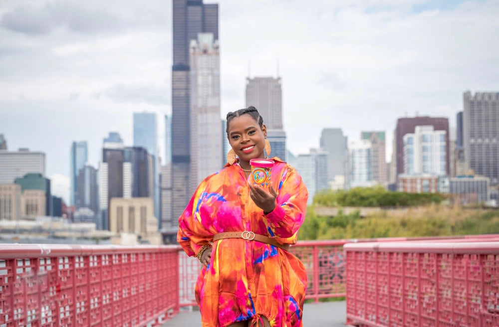 Ida Nelson holding a pint of her delicious ice cream with the Chicago skyline in the background